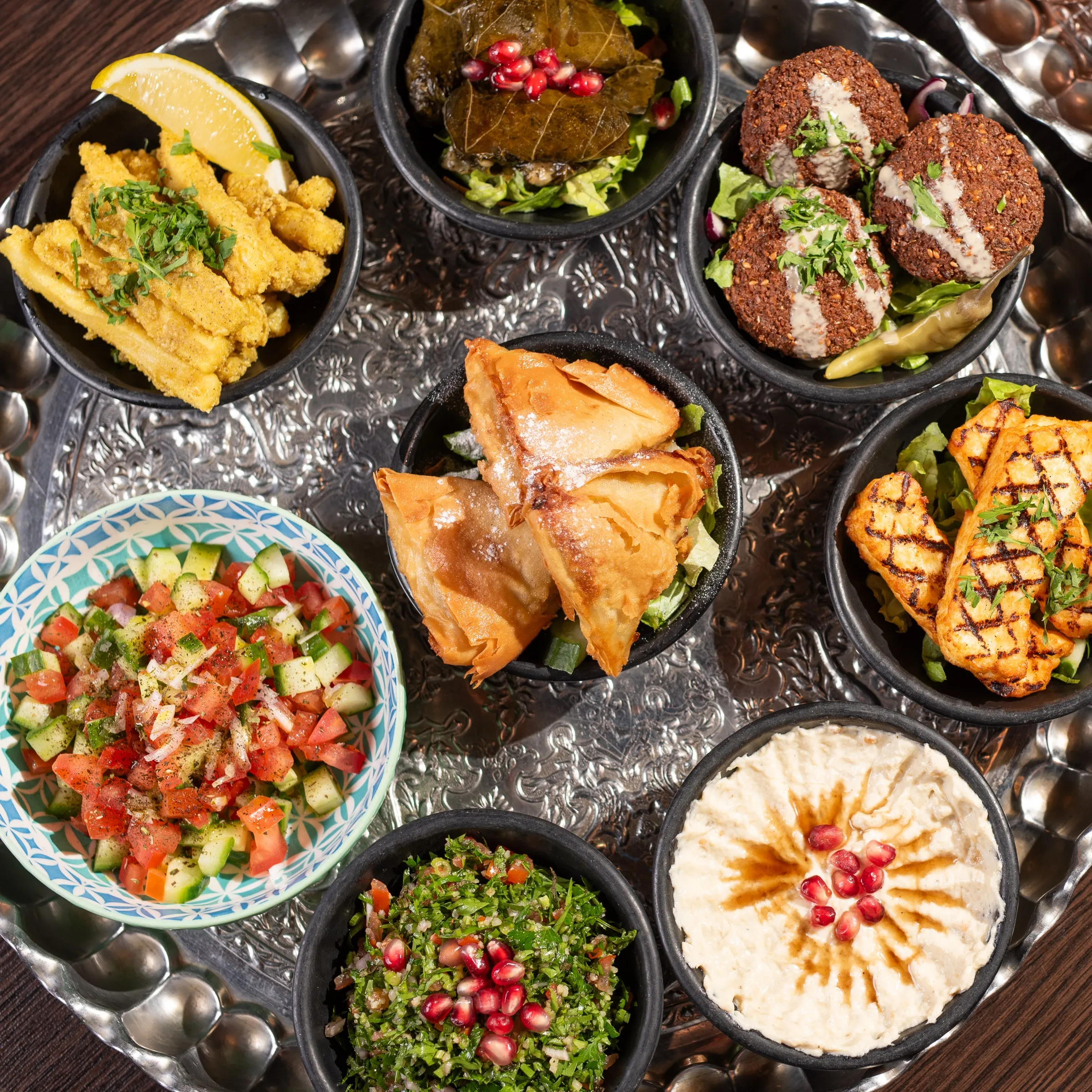 A spread of mezze including hummus, served to share